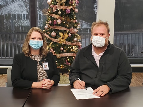 Woman and Man wearing face mask in front of Christmas tree